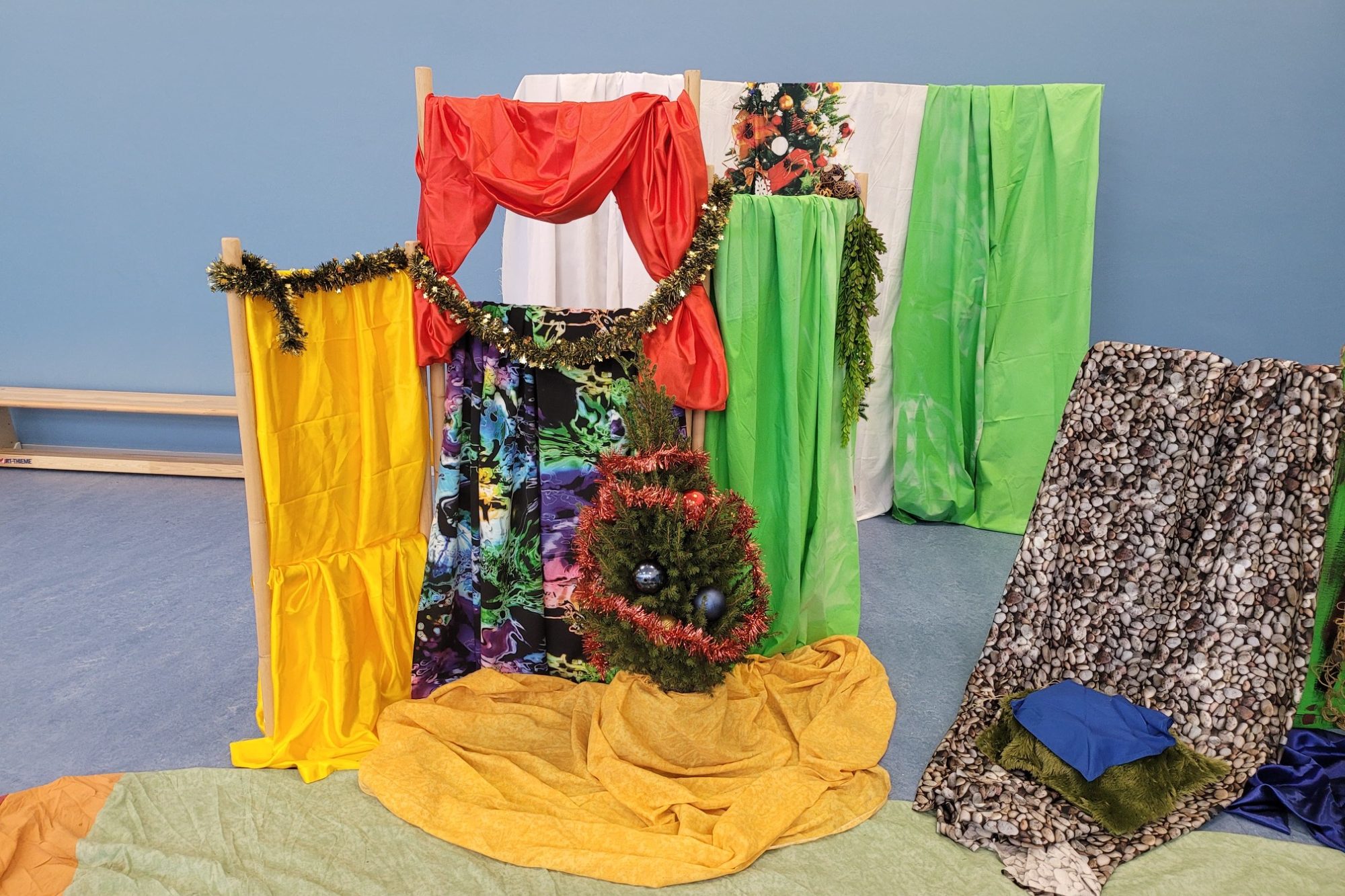 Bunte Stoffe und Drapierungen bilden eine kreative Kulisse.