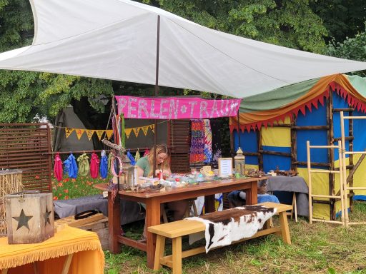 Marktstand mit bunten Dekorationen und einer lächelnden Verkäuferin.