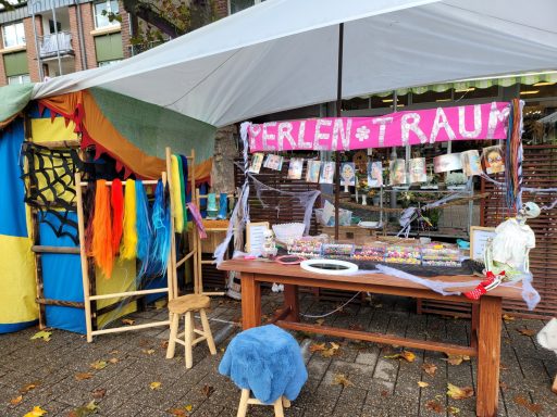 Marktstand mit bunten Stoffen, Tisch, Dekoration und Schild "Erlebnisträume".