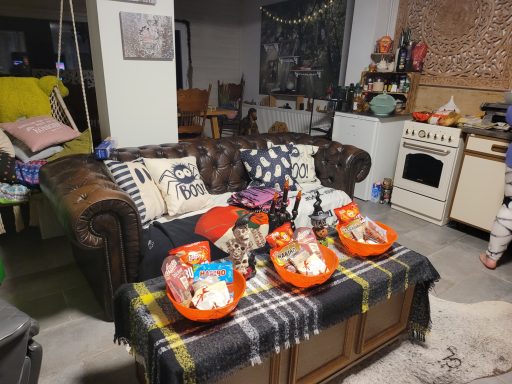 Gemütliche Sitzecke mit einem Chesterfield-Sofa und Körben voller Süßigkeiten darauf.