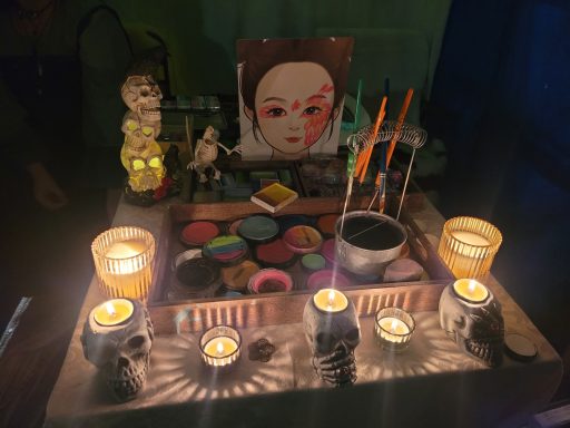 Ein ritueller Altar mit Kerzen, Farben, Statuen und einem Porträt.