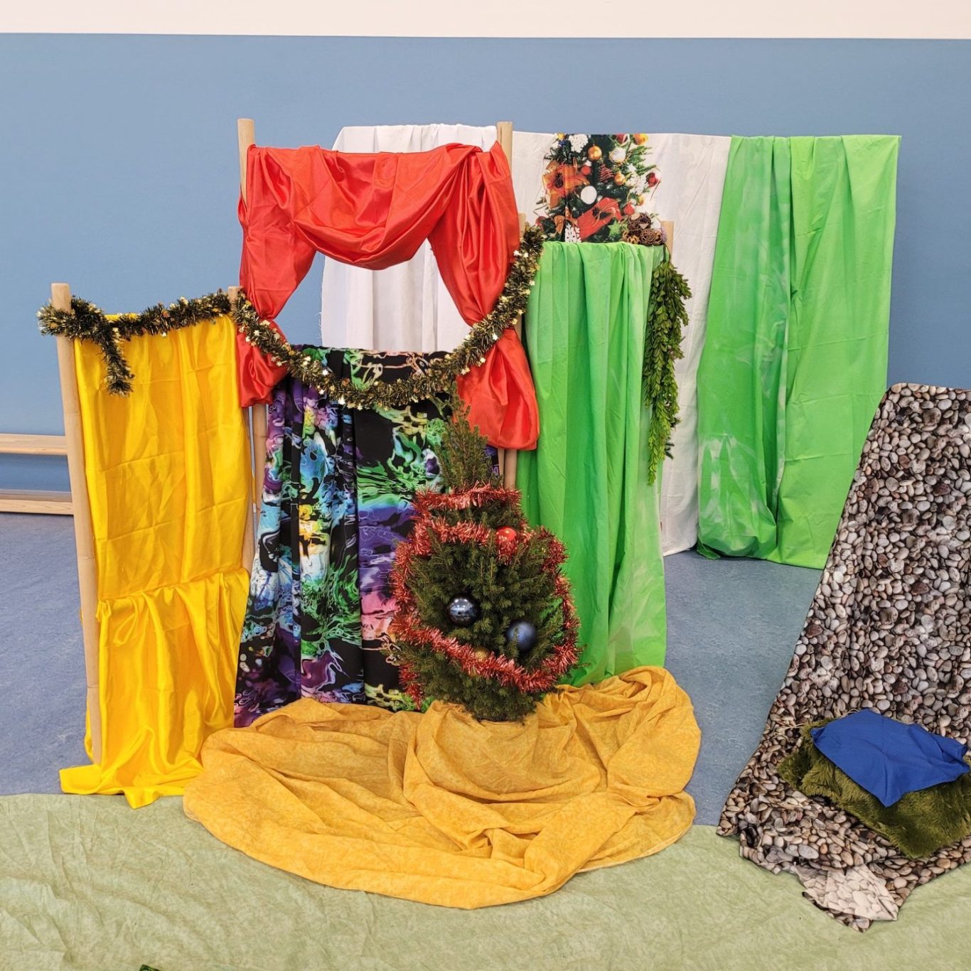 Bunte Tücher und Stoffe in verschiedenen Farben bilden eine kreative Kulisse.