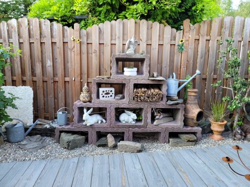 Dekorative Gartenlandschaft mit Steinen, Pflanzen und Figuren von Tieren.